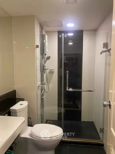 Modern bathroom with glass shower enclosure and sleek fixtures