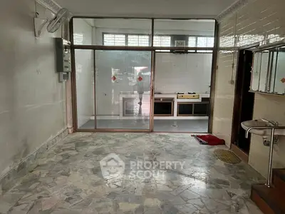 Spacious kitchen with open layout and gas stove, featuring tiled floors and ample natural light.