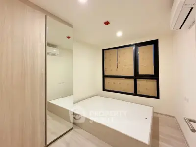 Modern bedroom with built-in wardrobe and large window in a minimalist design.