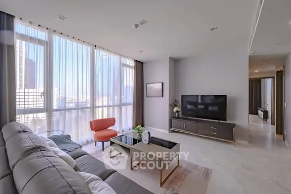 Spacious modern living room with large windows and stylish furniture in a luxury apartment.