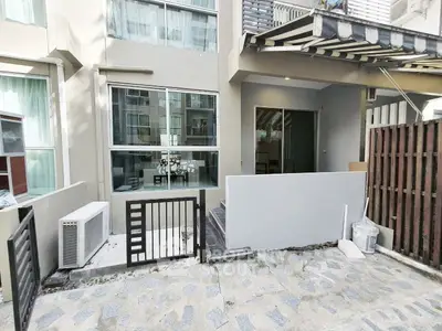 Modern townhouse exterior with large windows and small gated entrance