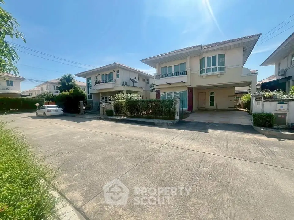 Charming suburban homes with spacious driveways and lush greenery under a clear blue sky.