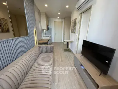 Modern living room with sleek design, featuring a plush sofa, flat-screen TV, and stylish decor in a cozy apartment.