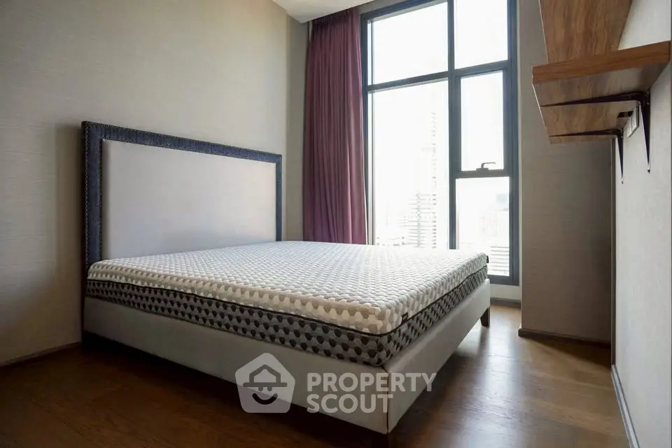 Spacious bedroom with large window and modern decor