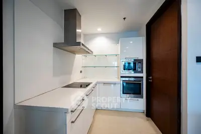 Modern kitchen with sleek white cabinetry and built-in appliances in a contemporary apartment.
