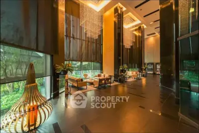 Luxurious high-ceiling lobby with elegant lighting and modern decor in upscale building.