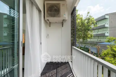 Charming balcony with air conditioning unit and urban view, perfect for relaxation in a modern apartment.