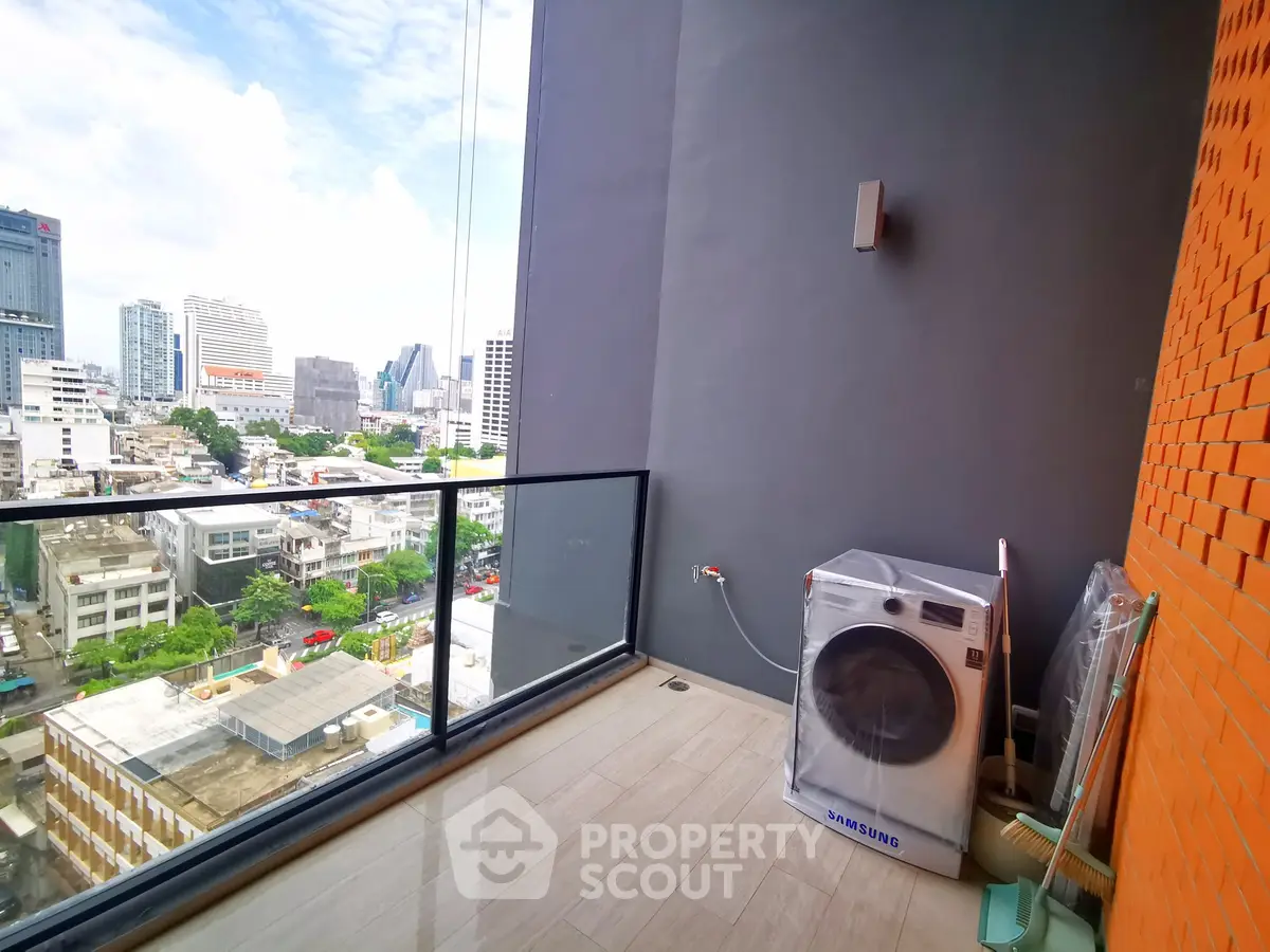 Spacious balcony with city view and washing machine in modern apartment.