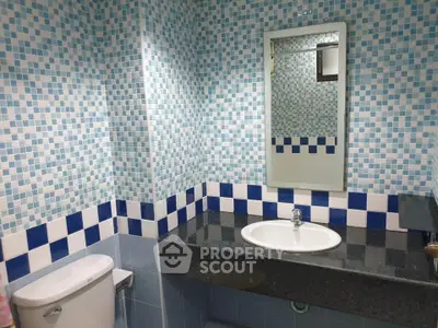 Charming bathroom with blue mosaic tiles and modern fixtures, perfect for a refreshing start to your day.