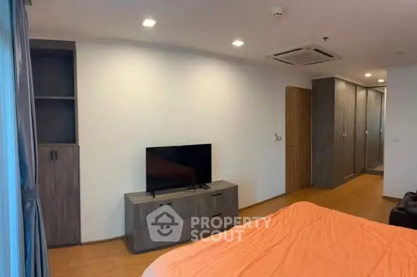 Modern bedroom with sleek furniture and built-in wardrobe