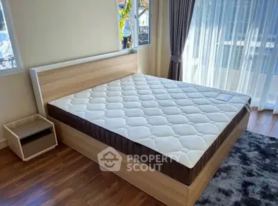 Spacious bedroom with large bed and natural light from floor-to-ceiling windows.