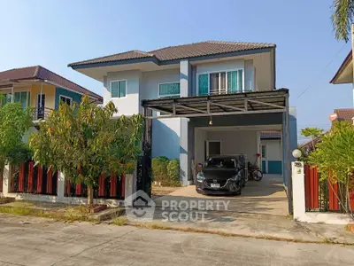 Charming two-story house with carport and lush garden in a serene neighborhood.