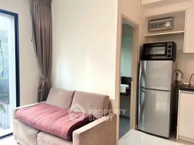 Cozy living area with modern kitchen and stainless steel appliances in a stylish apartment.