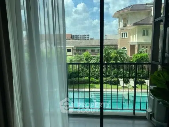 Stunning view from balcony overlooking pool and lush greenery in luxury property.