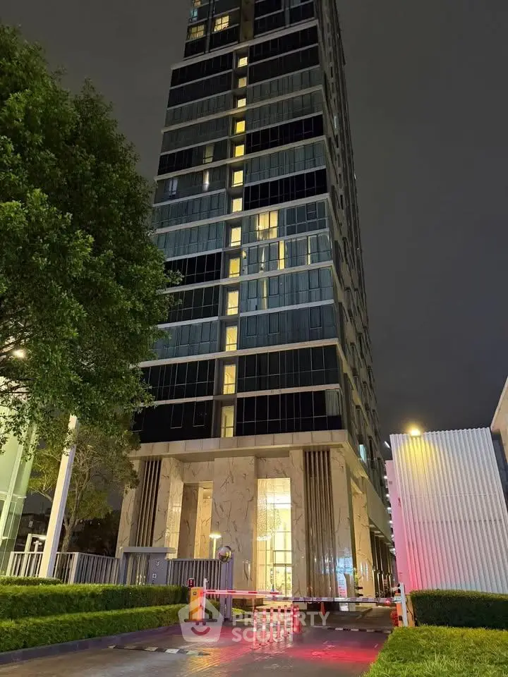 Stunning modern high-rise building exterior with elegant entrance at night, showcasing urban luxury living.