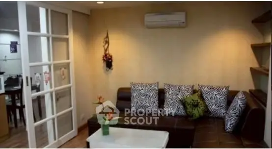 Stylish living room with modern decor and zebra print cushions, featuring a cozy sectional sofa and elegant sliding doors.