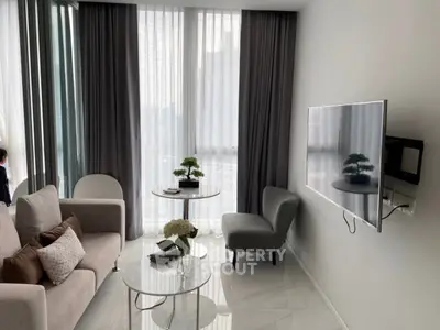 Modern living room with sleek furniture and large windows offering natural light.