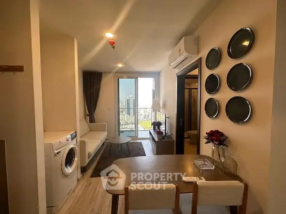 Modern apartment interior with open layout, featuring a cozy living area and city view balcony.