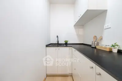 Modern minimalist kitchen with sleek black countertops and white cabinetry