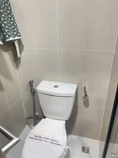 Modern bathroom with sleek toilet and neutral tiles, perfect for minimalist design enthusiasts.