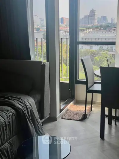 Modern apartment with cozy living area and balcony offering city views.