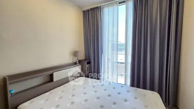 Cozy bedroom with large window and modern furnishings in a stylish apartment.