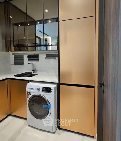 Modern kitchen with sleek cabinetry and built-in washing machine