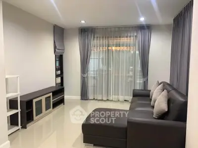 Modern living room with sleek furniture and large window drapes
