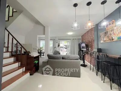 Modern living room with stylish decor and open layout, featuring a cozy sofa and elegant lighting.