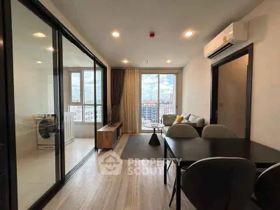 Modern living room with city view, featuring sleek furniture and large windows for natural light.