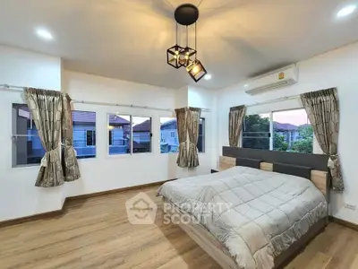 Spacious bedroom with modern lighting and large windows offering a serene view.