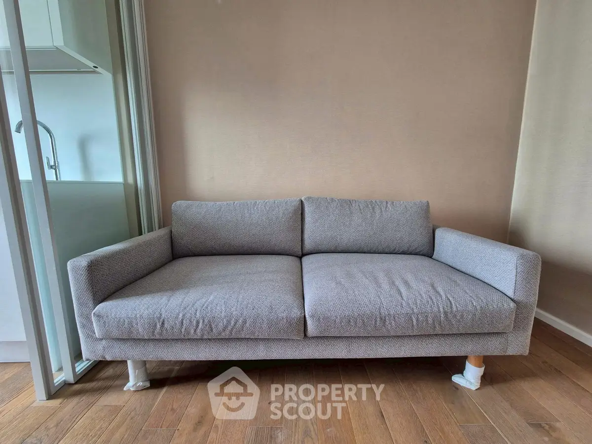 Modern living room with stylish gray sofa and wooden flooring