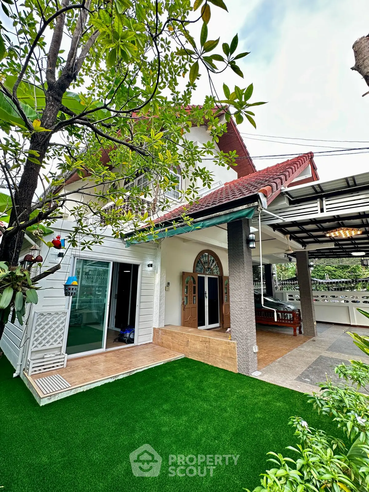 Charming two-story house with lush garden and spacious patio, perfect for family living.