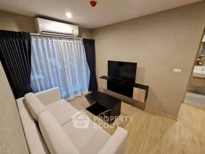 Modern living room with sleek furniture and large window, perfect for cozy evenings.