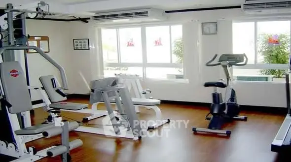 Spacious home gym with modern fitness equipment and large windows.