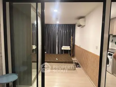 Modern bedroom with sleek design, featuring a large bed, mirrored wardrobe, and air conditioning.