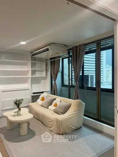 Modern living room with cozy sofa, large windows, and built-in shelves in a stylish apartment.