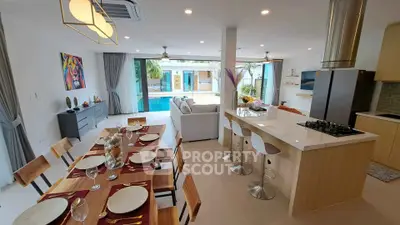 Luxurious open-plan living room with modern kitchen and pool view