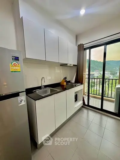 Modern kitchen with sleek cabinets and balcony view