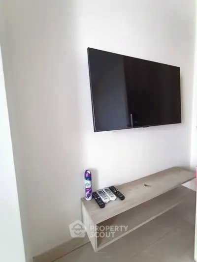 Modern living room with wall-mounted TV and sleek wooden console table.