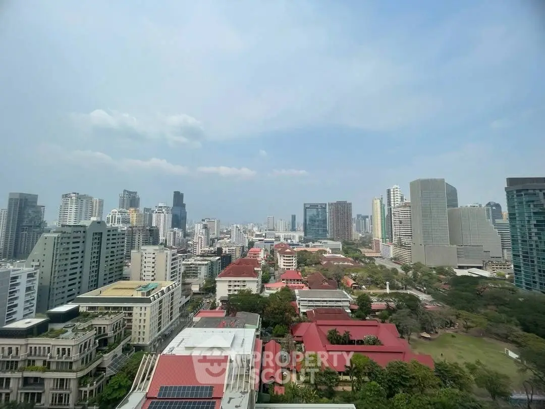 Stunning cityscape view from high-rise building showcasing urban skyline and lush greenery.