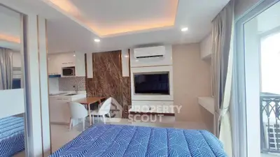 Modern studio apartment with stylish decor and open layout, featuring a cozy bed and compact kitchen area.