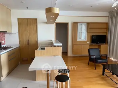 Modern open-layout kitchen and living area with wooden finishes and sleek furniture.