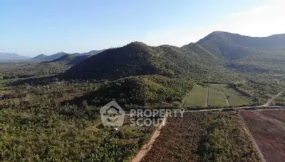 Scenic aerial view of lush green hills and expansive landscape, ideal for real estate development.