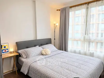Cozy bedroom with modern decor and large windows offering natural light