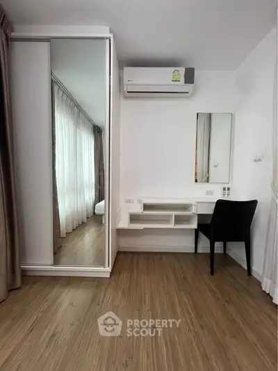 Modern bedroom with mirrored wardrobe and sleek vanity desk