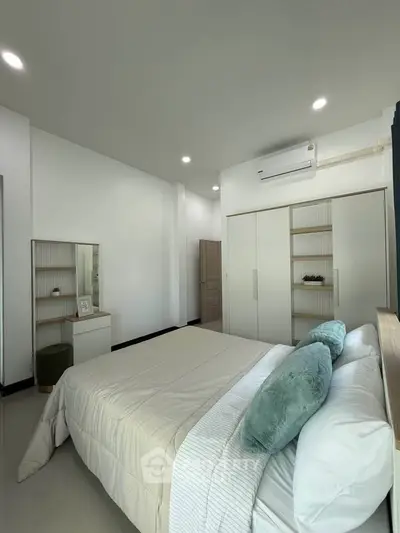 Modern bedroom with sleek design, featuring a cozy bed, built-in wardrobe, and air conditioning.