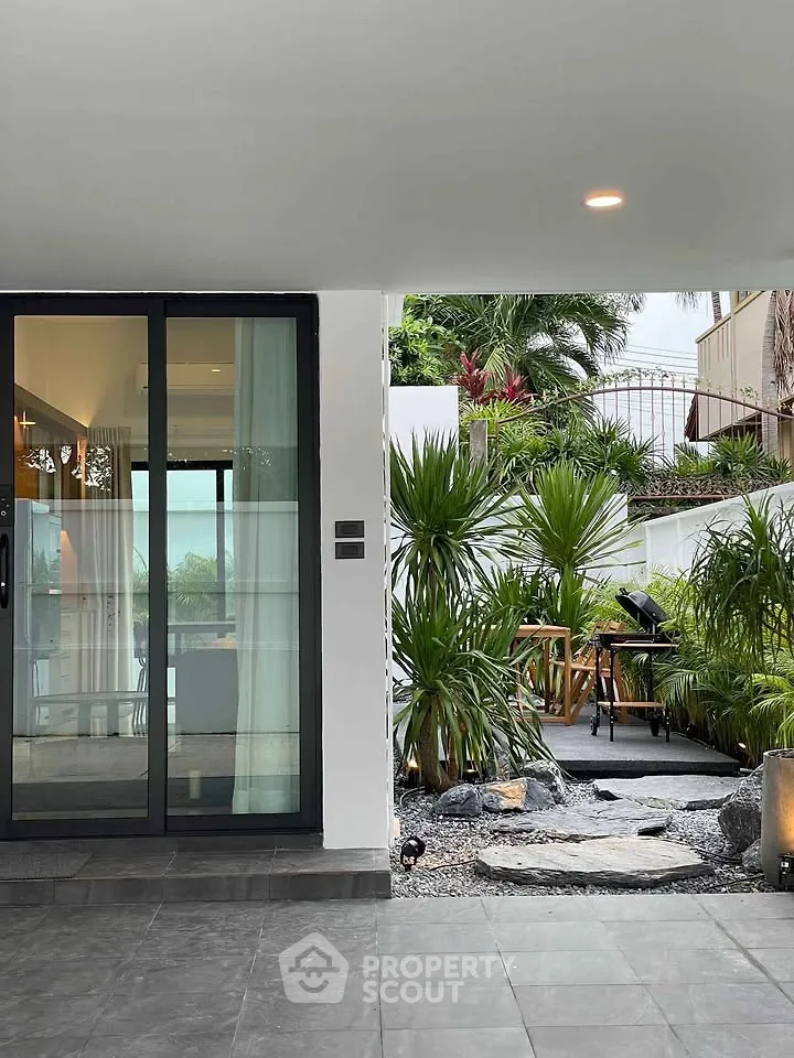 Modern home with lush garden and stylish patio area, perfect for outdoor relaxation.