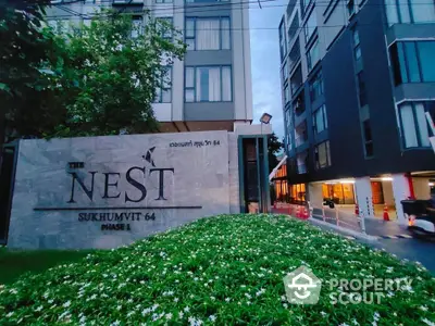 Modern condominium entrance with lush greenery at The Nest Sukhumvit 64 Phase 1