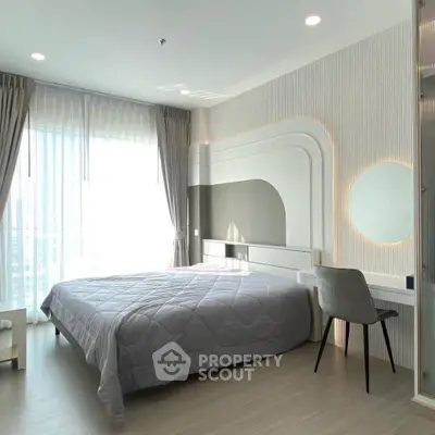 Modern bedroom with stylish decor and large window offering natural light.
